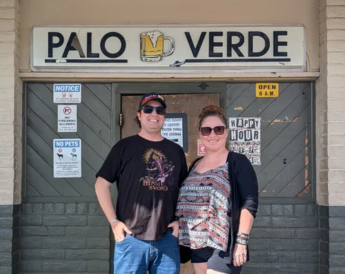 Anna and Levi at the Yucca Taproom with the Palo Verde sign
